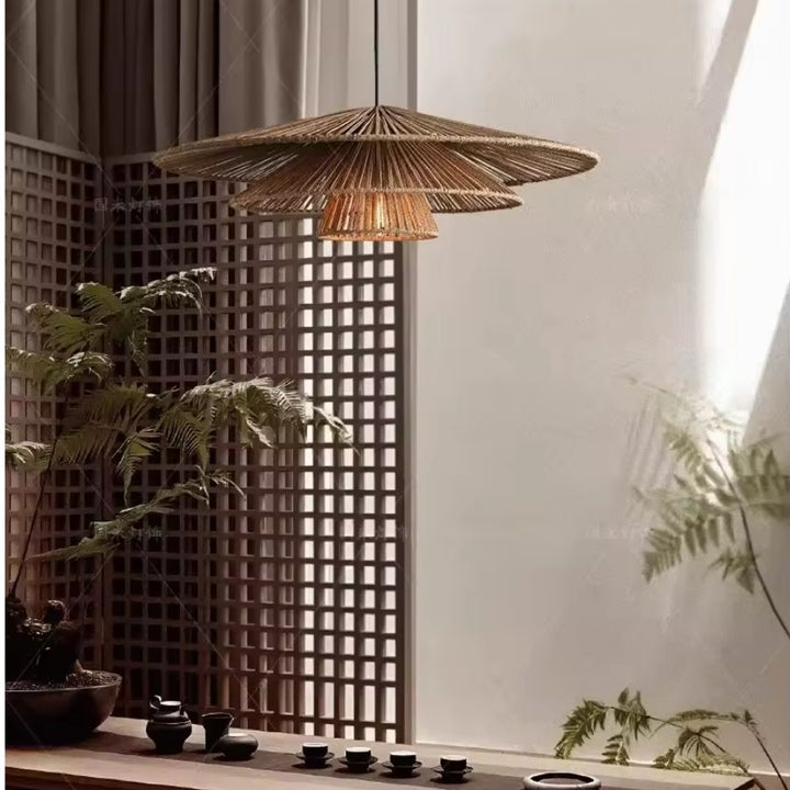 Dans un espace zen d'inspiration japonaise, suspension en rotin à trois abat-jour étagés au-dessus d'une table à thé.
