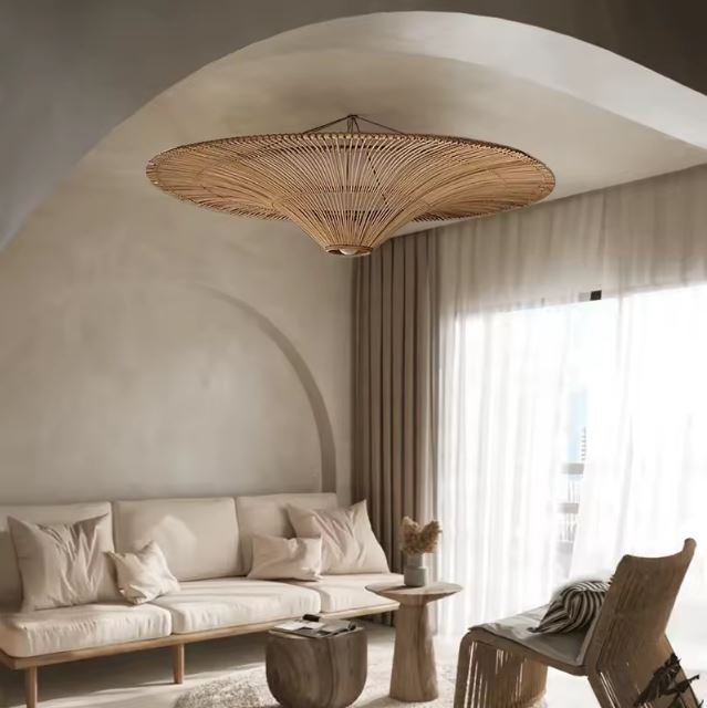 Suspension rotin XXL dans un salon minimaliste avec voûte, apportant une touche naturelle et apaisante à la décoration.