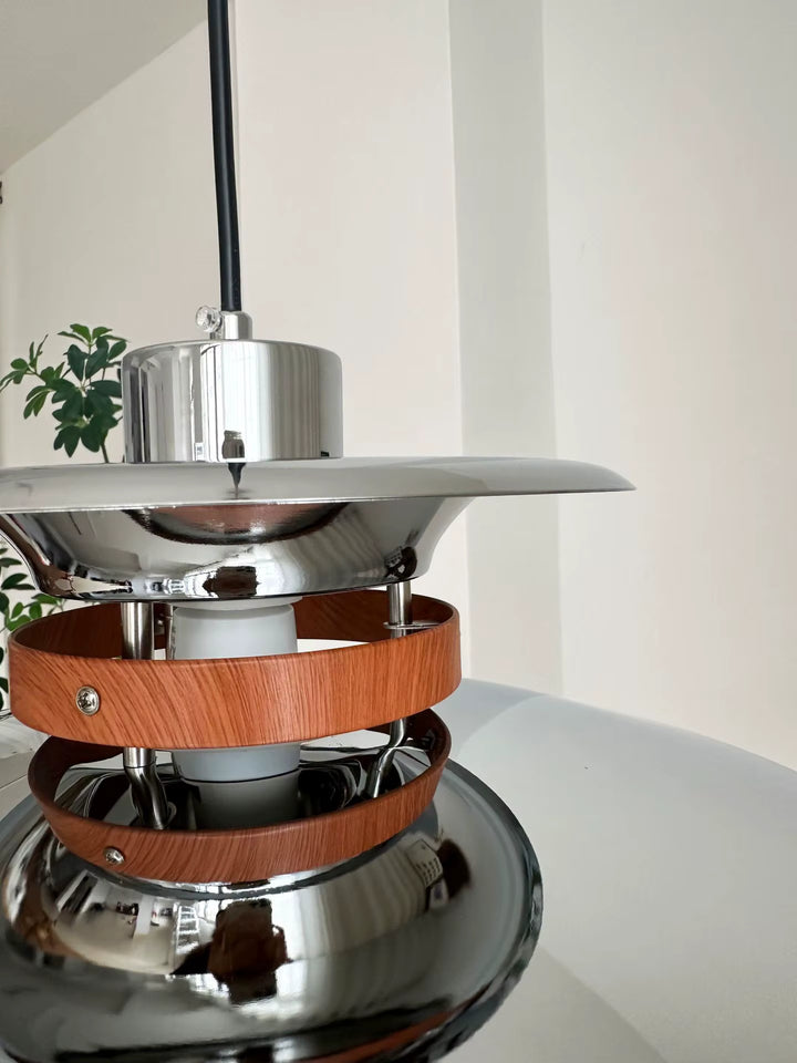 Gros plan sur les disques chromés et anneaux effet bois d’une suspension scandinave vintage au design années 60