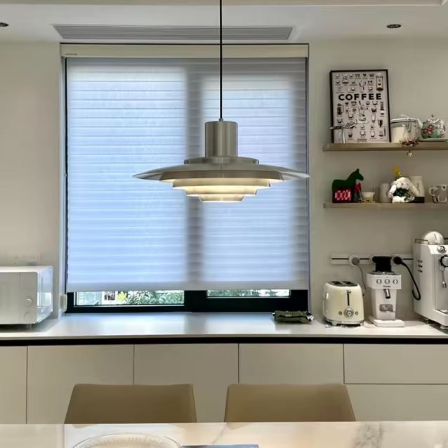 Luminaire suspendu à disques métalliques étagés, au charme scandinave vintage dans une cuisine contemporaine.