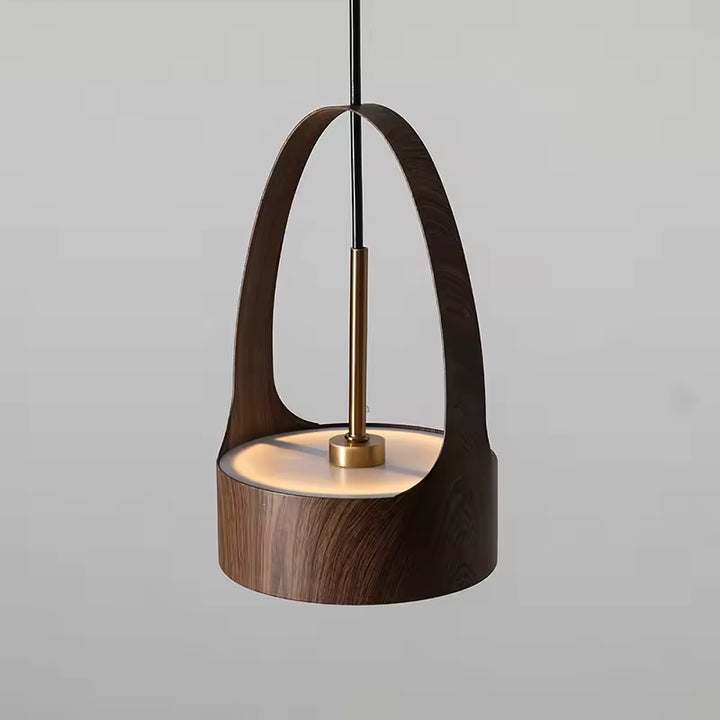 Vue rapprochée d’une suspension à arche effet bois, soulignée par une tige dorée et un design sculptural contemporain