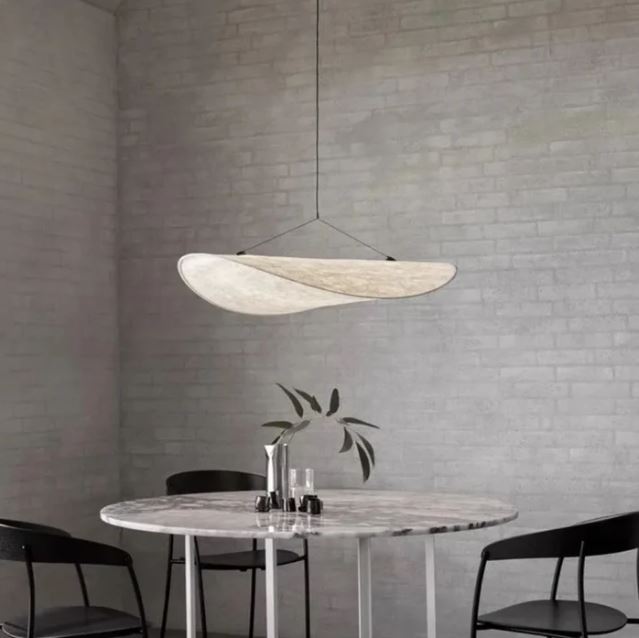 Suspension en soie au design minimaliste suspendue au-dessus d'une table en marbre, ajoutant une touche d'élégance contemporaine.