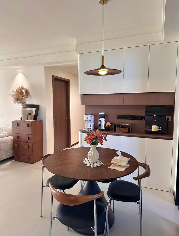 Suspension soucoupe effet bois au style scandinave rétro éclairant une table ronde dans une salle à manger épurée