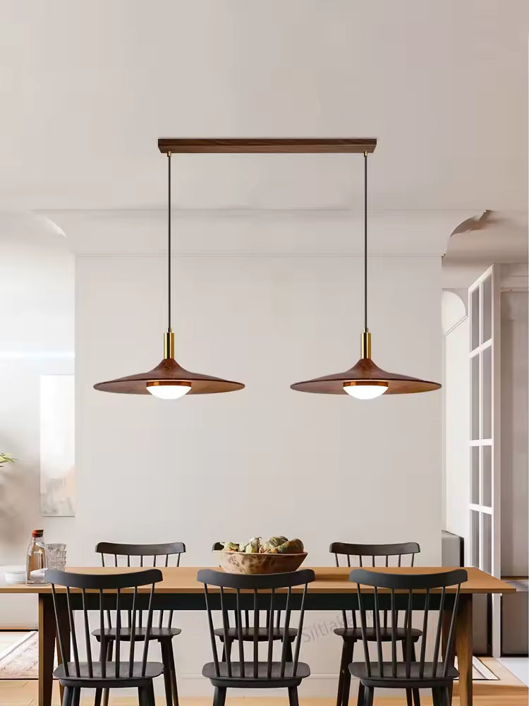Suspension double effet bois en forme de soucoupe au style vintage années 60 installée au-dessus d’une table à manger