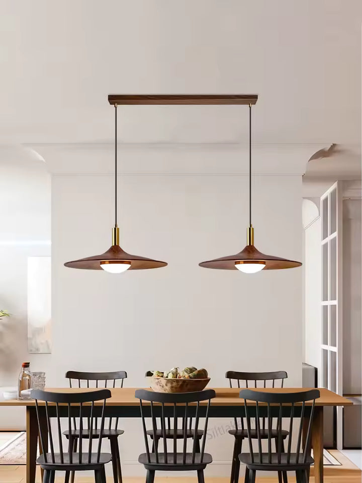 Suspension double effet bois en forme de soucoupe au style vintage années 60 installée au-dessus d’une table à manger