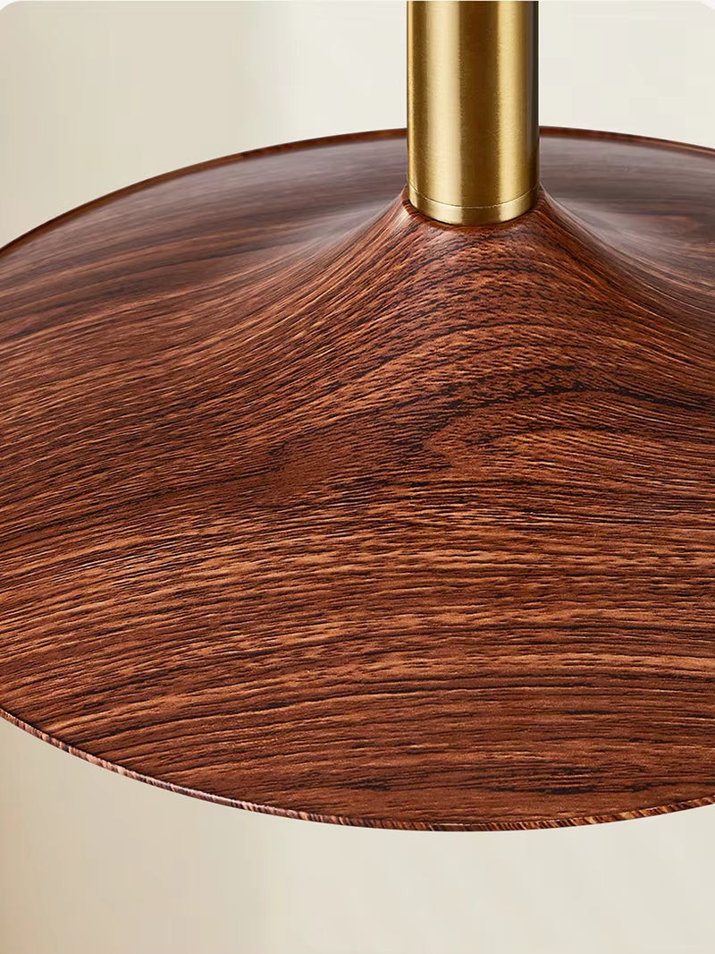 Gros plan sur la suspension soucoupe en métal effet bois veiné et finition dorée au style vintage années 60