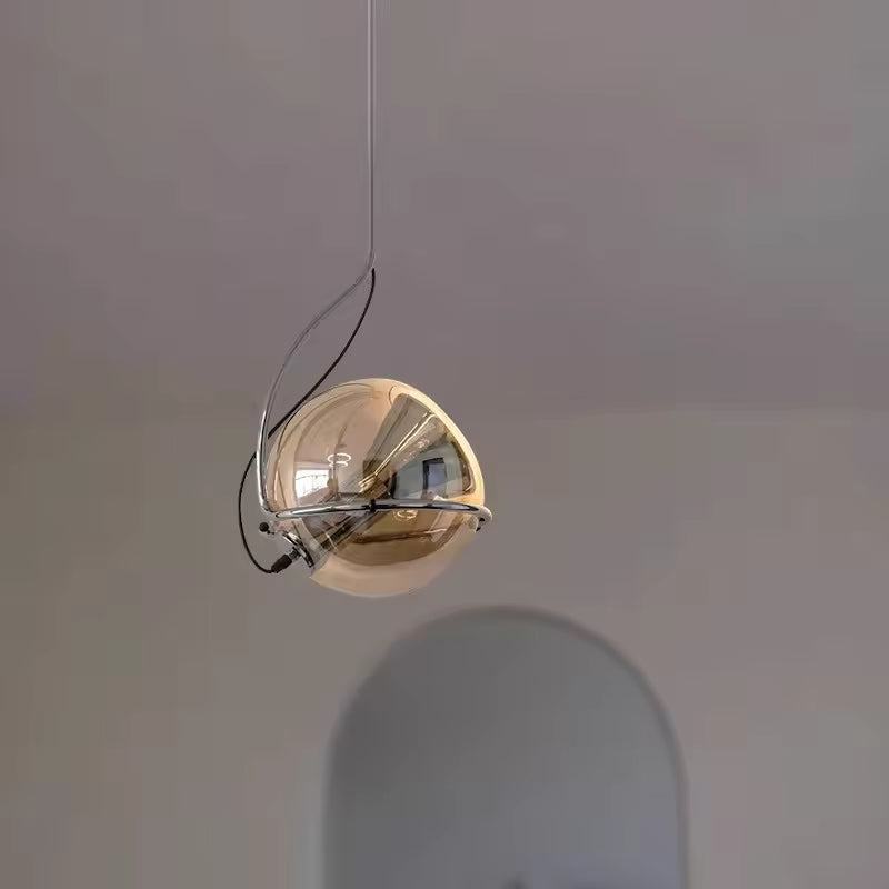 Suspension sphérique en verre ambré et chrome, mise en scène dans un intérieur sobre au style minimaliste