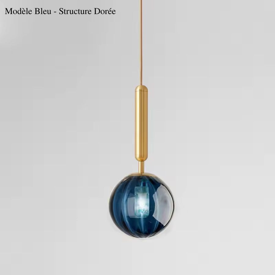 Globe en verre bleu intense rehaussé d’une structure dorée élancée, dans un esprit design élégant et coloré