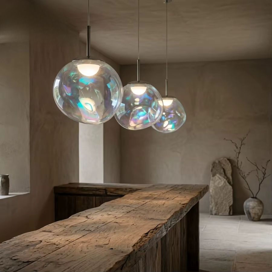 Suspension sphère en verre irisé aux reflets arc-en-ciel, composition contemporaine au-dessus d’un îlot de cuisine