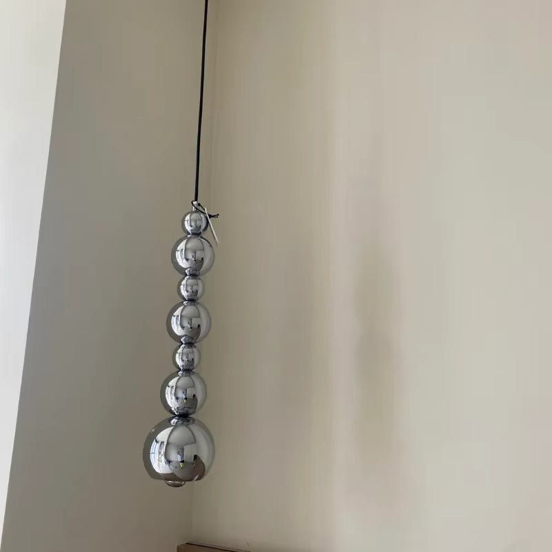 Jeu vertical de sphères chromées effet miroir pour une suspension au design minimaliste, sculptural et contemporain