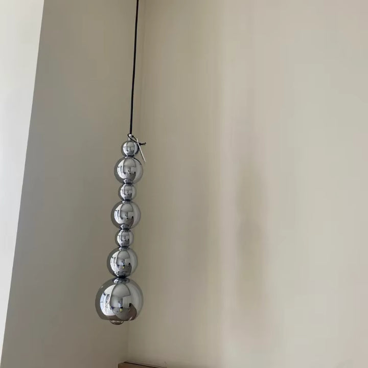 Jeu vertical de sphères chromées effet miroir pour une suspension au design minimaliste, sculptural et contemporain