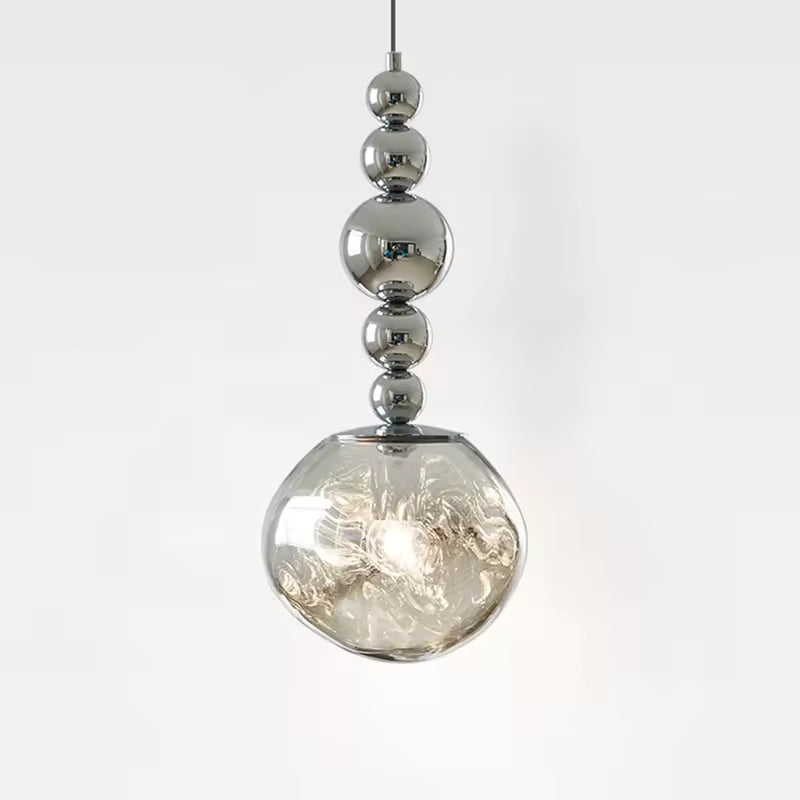 Cinq sphères chromées dominent un globe transparent texturé, créant une suspension sculpturale aux reflets précieux