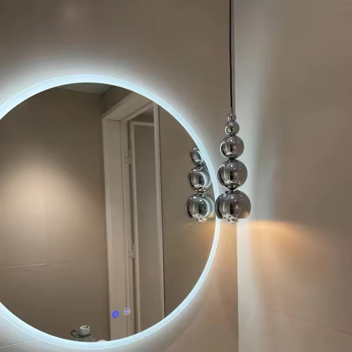 Reflets miroir et sphères chromées suspendues composent un luminaire sculptural au design futuriste et contemporain