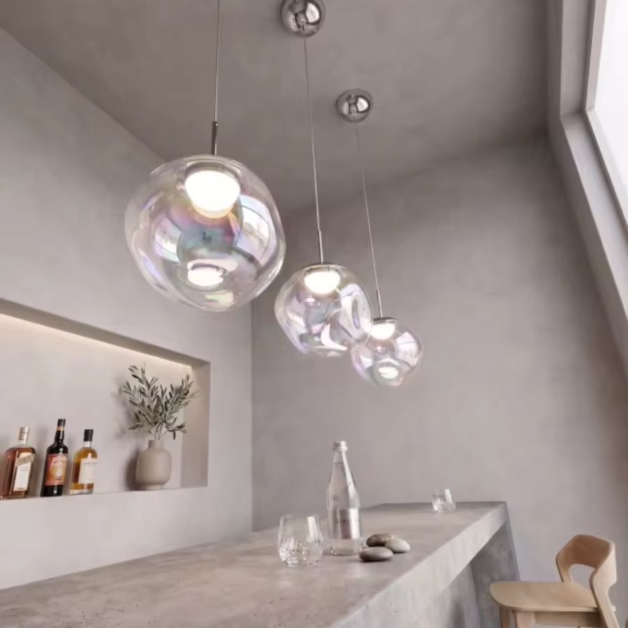 Suspension de sphères en verre irisé au-dessus d’un comptoir, dans un décor minimaliste aux lignes contemporaines