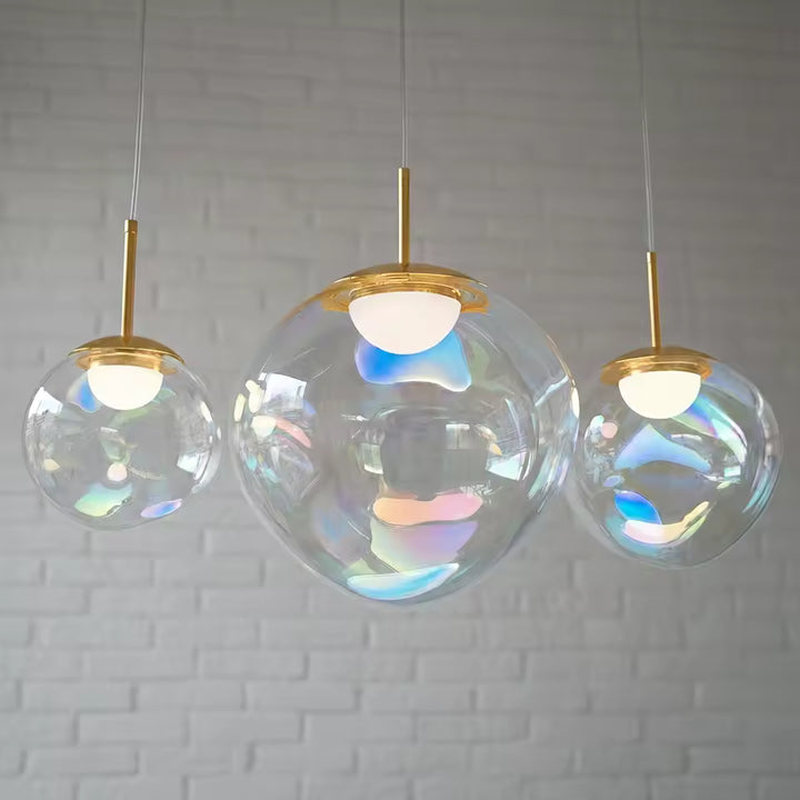 Suspension à trois sphères en verre irisé avec finitions dorées, design élégant aux reflets pastel et nacrés
