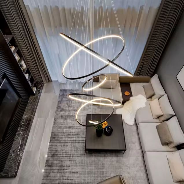 Suspension spirale LED noire au design contemporain, grand luminaire sculptural pour salon avec plafond cathédrale et vide sur séjour.