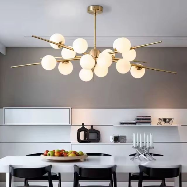 Suspension Sputnik en laiton avec globes en verre, idéale pour illuminer une cuisine moderne avec une touche design et sophistiquée.