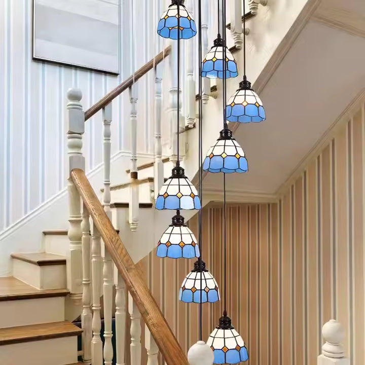 Suspension Tiffany vintage à plusieurs lampes en verre bleu disposées en cascade dans une cage d’escalier