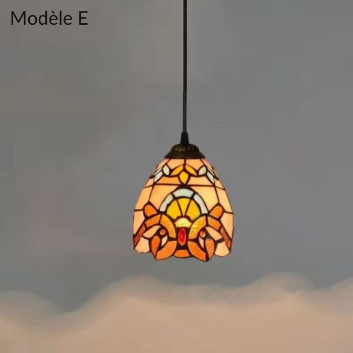 Suspension Tiffany modèle E avec motifs orange et jaune, idéale pour une ambiance chaleureuse et une décoration vintage.