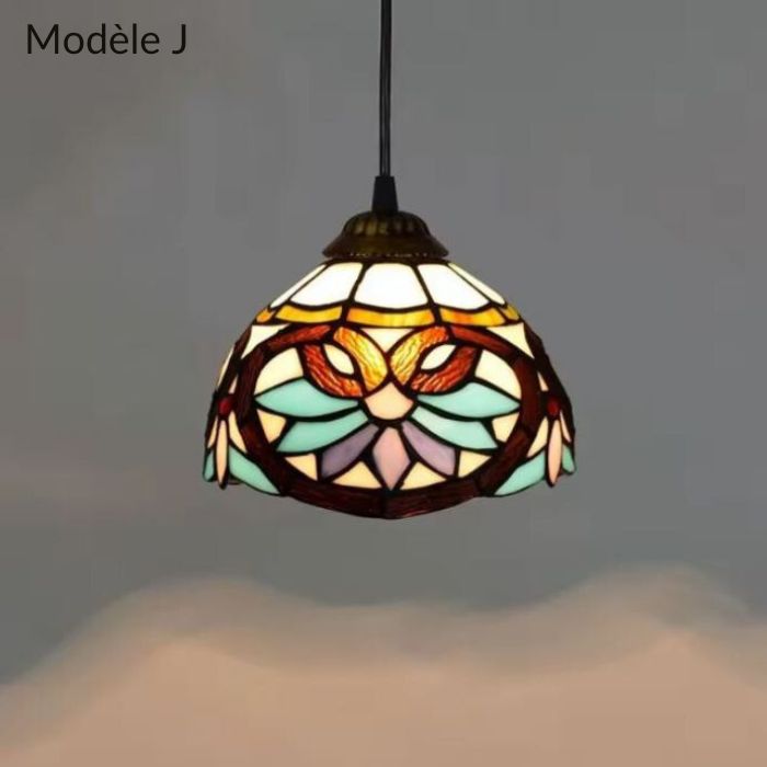 Suspension Tiffany modèle J avec vitrail multicolore et motifs décoratifs, parfait pour un éclairage sophistiqué.