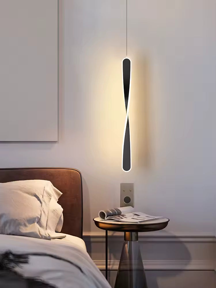 Près du chevet, une suspension noire torsadée au contour lumineux dessine une silhouette moderne et sculpturale