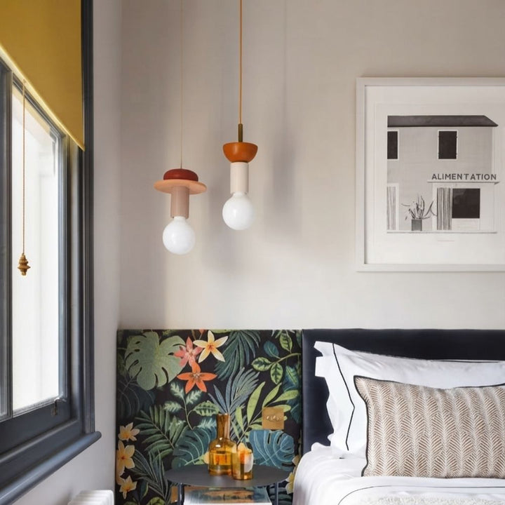 Suspension totem en bois coloré suspendue au-dessus d'une tête de lit dans une chambre élégante