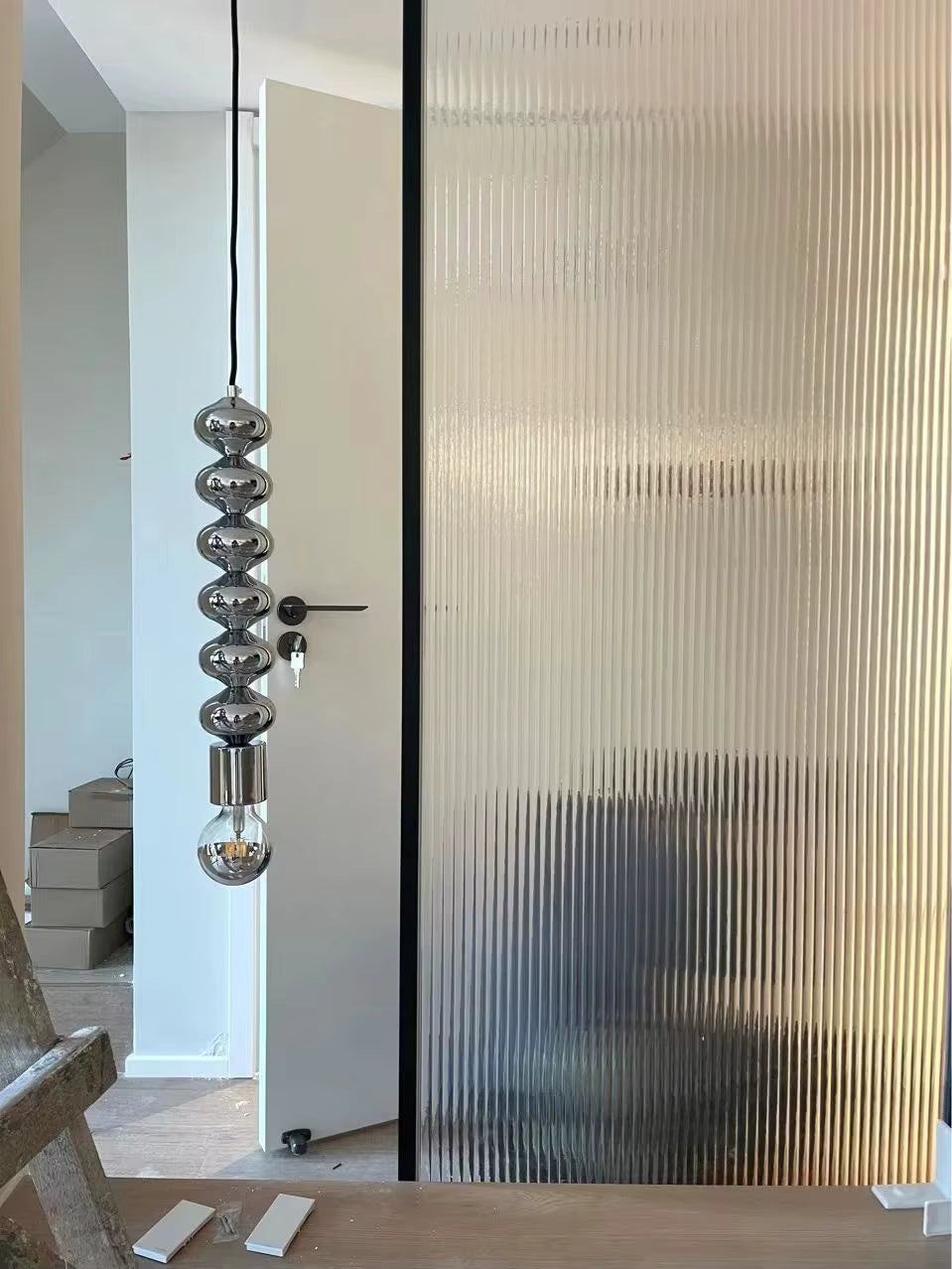 Forme totem chromée et finition miroir pour une suspension contemporaine au style sculptural et minimaliste