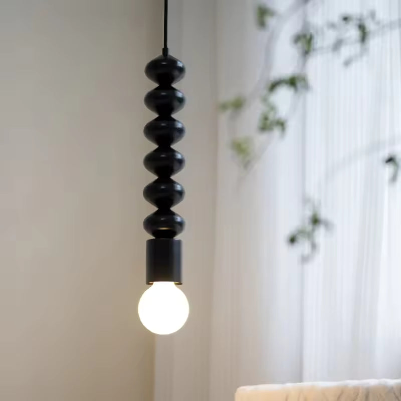 Suspension totem noire à ampoule globe lumineuse, au design minimaliste, sculptural et contemporain