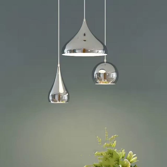 Trio de suspensions en métal argenté au design élégant, parfait pour illuminer un intérieur moderne et raffiné.