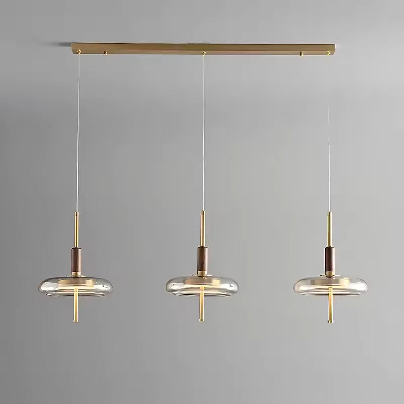 Suspension triple à anneaux de verre et tiges dorées, alliance de bois et métal au style minimaliste élégant