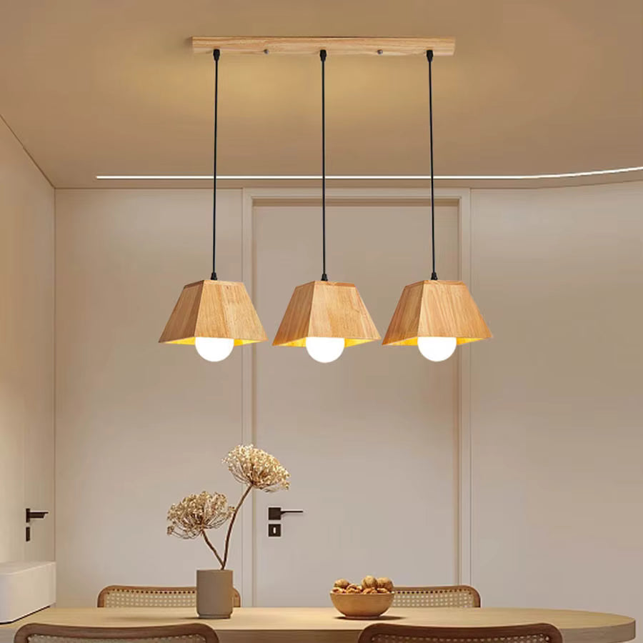 Suspension triple en bois géométrique à globes opalins, au-dessus d’une table dans un intérieur scandinave chaleureux