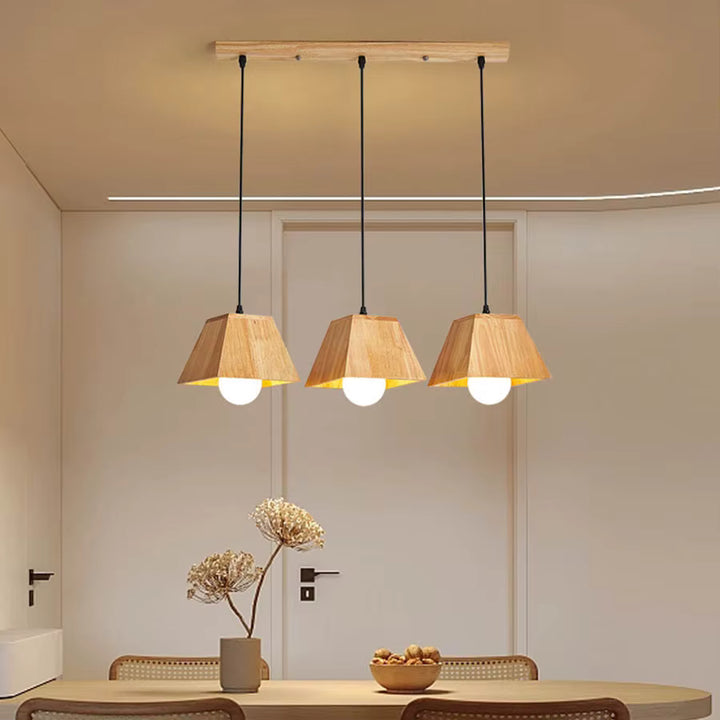 Suspension triple en bois géométrique à globes opalins, au-dessus d’une table dans un intérieur scandinave chaleureux