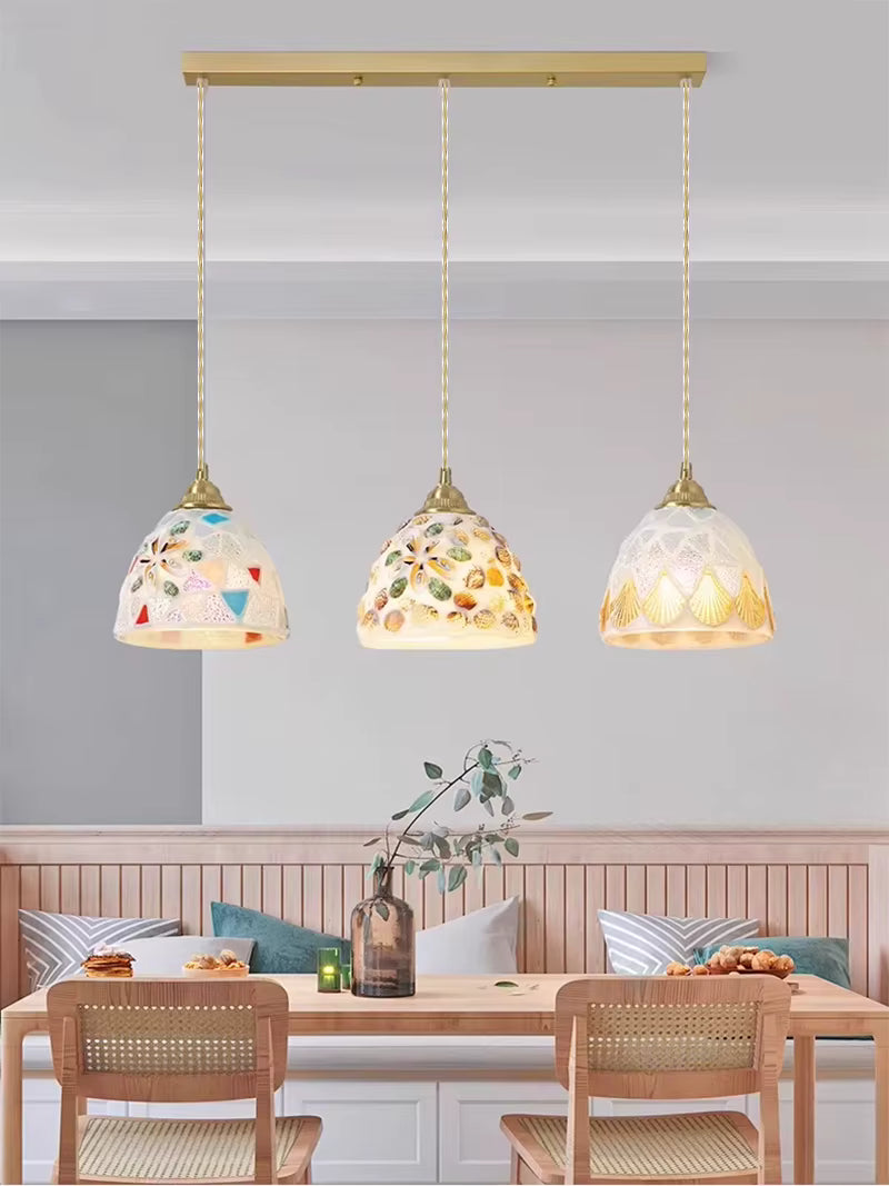Suspension triple en verre façonné à motifs de coquillages, apportant une touche bord de mer chic à la salle à manger