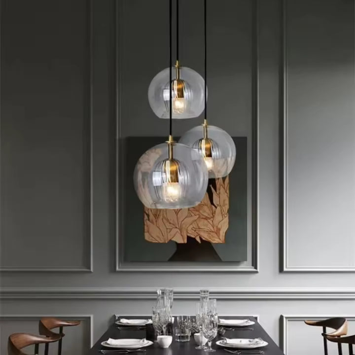 Suspension triple verre à cœur strié au-dessus d’une table de salle à manger contemporaine et élégante