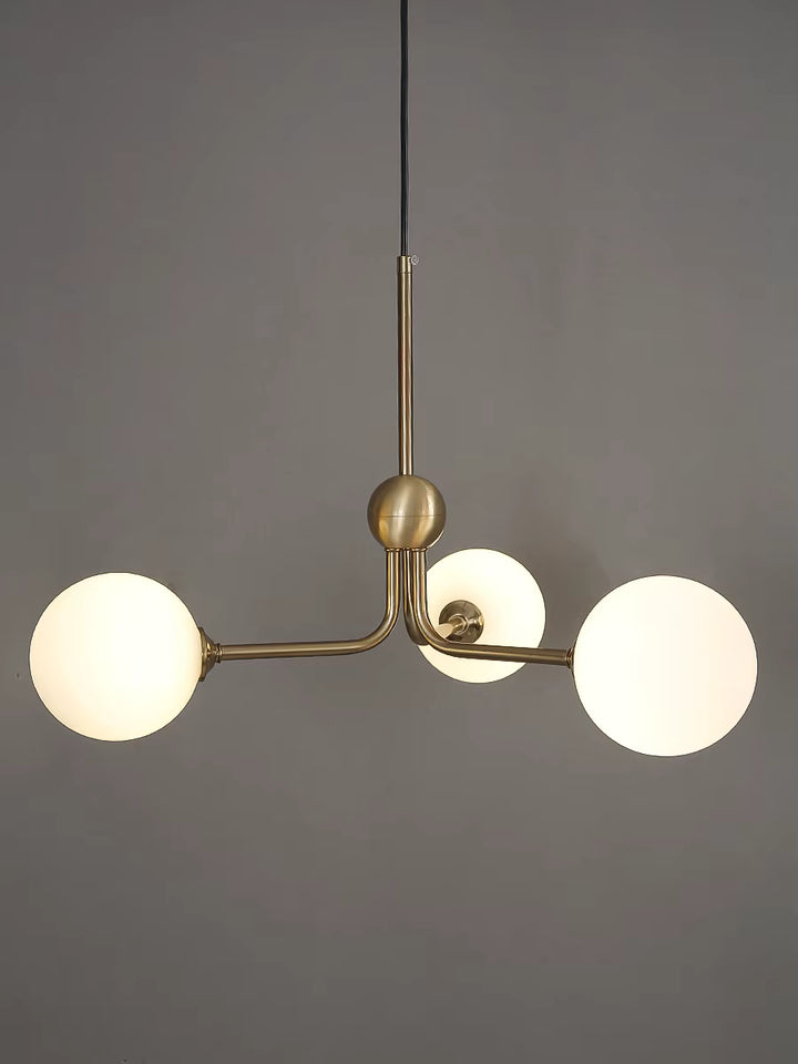 Suspension rétro à trois globes lumineux en verre opalin et structure dorée inspirée du design des années 50 et 60