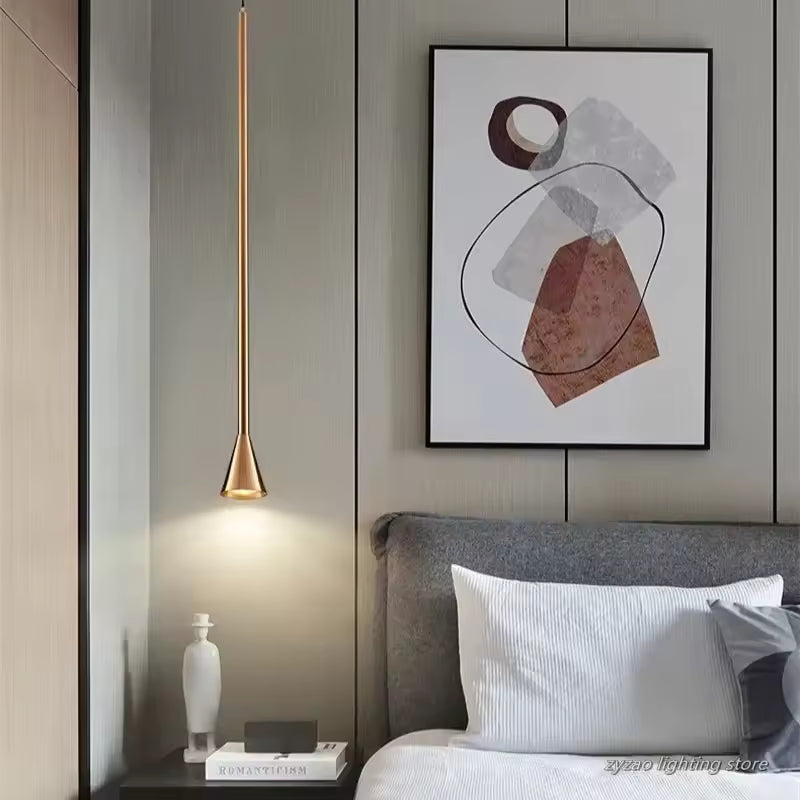 Suspension doré très élancé installé près du lit, avec extrémité trompette et style contemporain raffiné