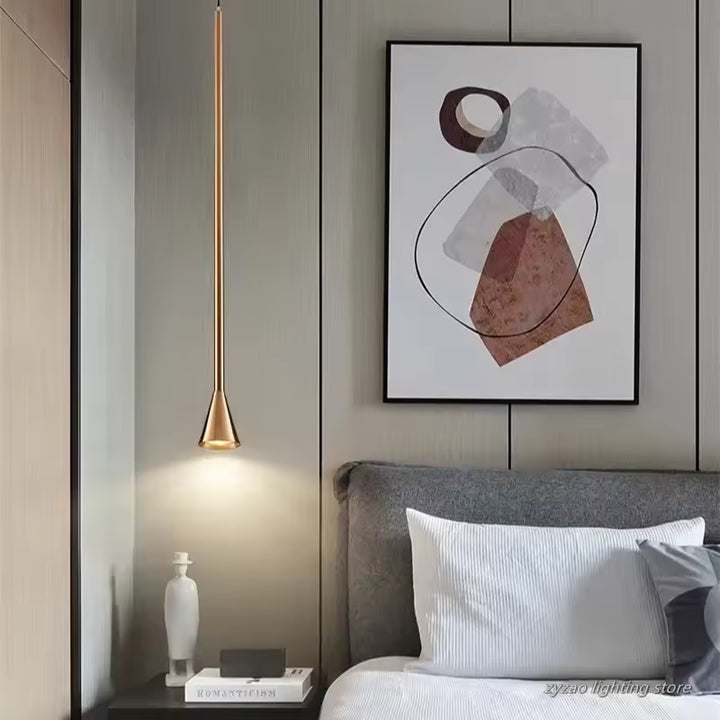Suspension doré très élancé installé près du lit, avec extrémité trompette et style contemporain raffiné