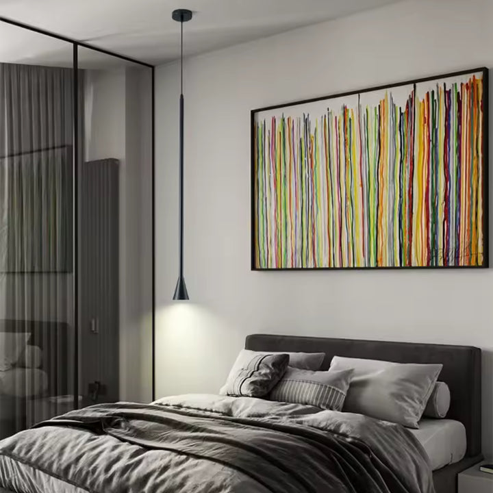 Une suspension noire très fine descend près du lit, avec embout trompette et esthétique moderne aux lignes épurées