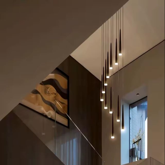 Suspension tube design noire avec LED, en descente élégante le long d’un escalier contemporain aux lignes graphiques et épurées.