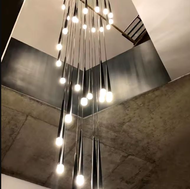 Suspension tube design noire avec ampoules LED, idéale pour très grande hauteur sous plafond dans un intérieur au style industriel.