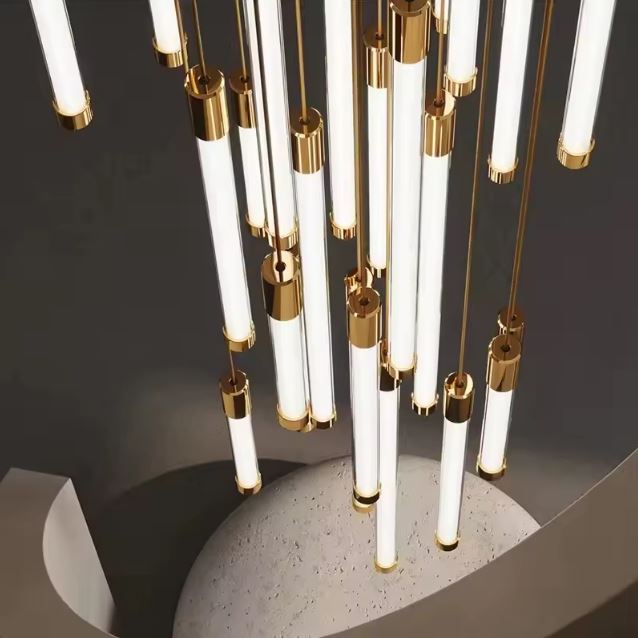 Suspension tube design vue du dessus, idéale pour cage d’escalier moderne avec ses lignes graphiques et finitions dorées élégantes.