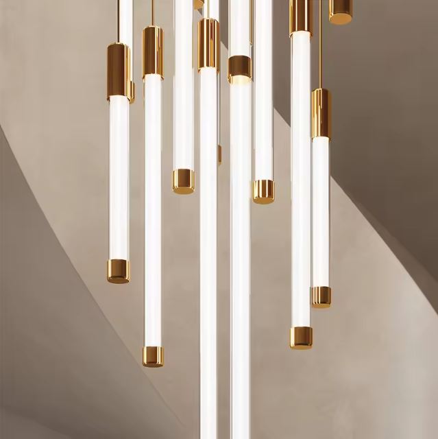 Suspension tube design dorée et blanche au style raffiné, parfaite pour sublimer un escalier ou une entrée au design chic et sculptural.