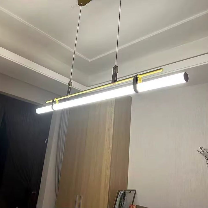 Suspension tube LED à structure dorée et attaches en cuir, au design industriel contemporain et minimaliste