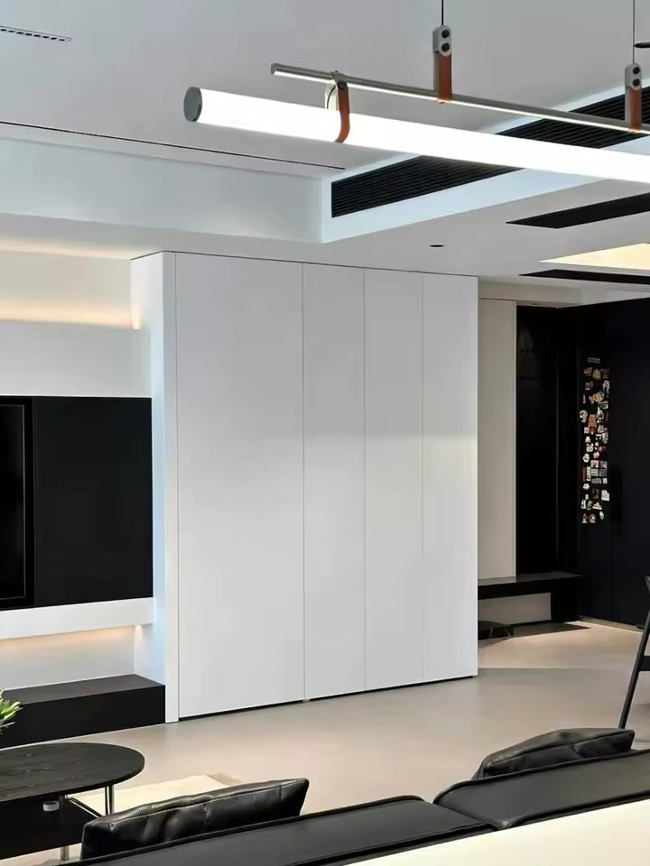 Tube néon LED suspendu à structure noire et attaches en cuir, intégré dans un salon moderne aux lignes minimalistes