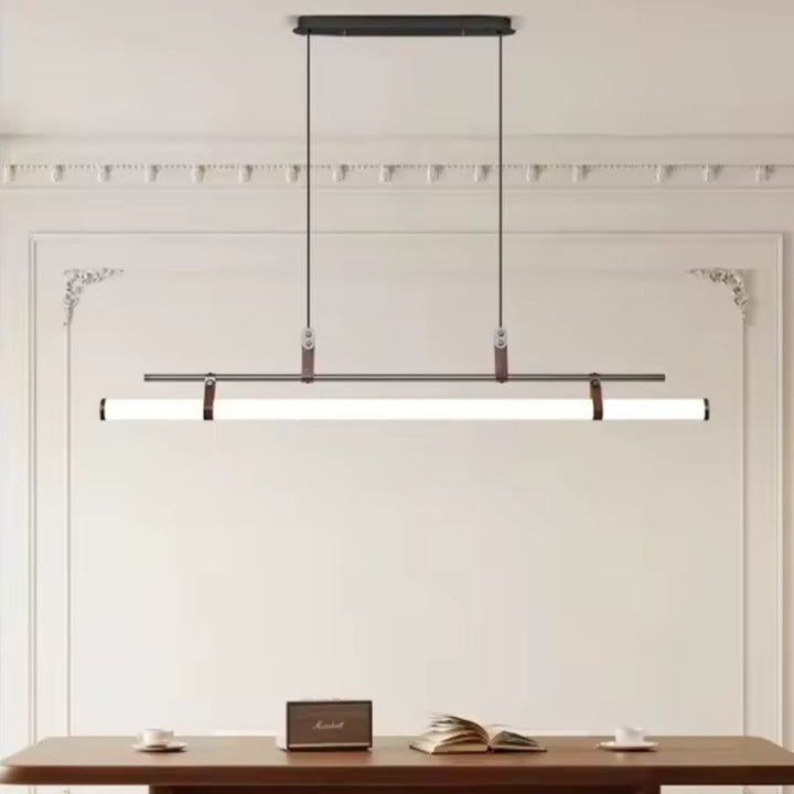 Suspension tube LED noire avec attaches en cuir, mise en valeur dans une salle à manger au style classique contemporain