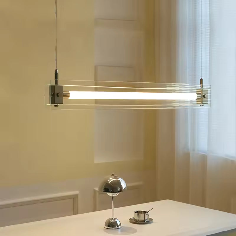 Suspension linéaire en verre transparent et acier inoxydable, traversé par un tube lumineux au design contemporain