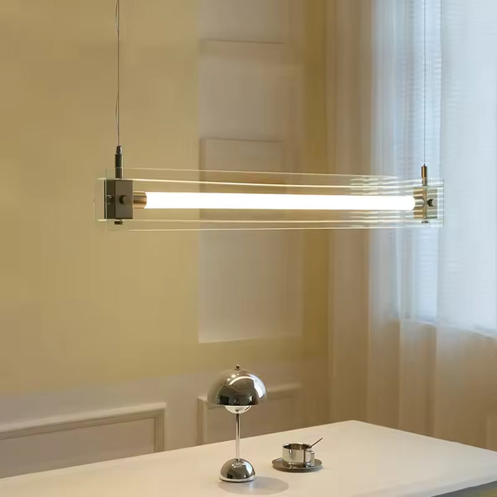 Suspension linéaire en verre transparent et acier inoxydable, traversé par un tube lumineux au design contemporain