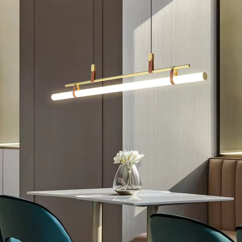 Suspension tube LED horizontal en laiton, suspendu au-dessus d’une table dans un intérieur contemporain