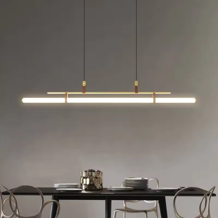 Ligne lumineuse néon LED dorée avec attaches en cuir, suspendue au-dessus d’une table dans une salle à manger moderne