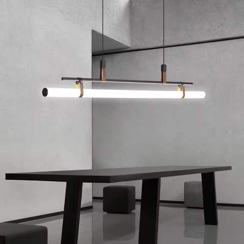 Suspension à tube LED, structure noire et attaches en cuir, dans un intérieur minimaliste contemporain